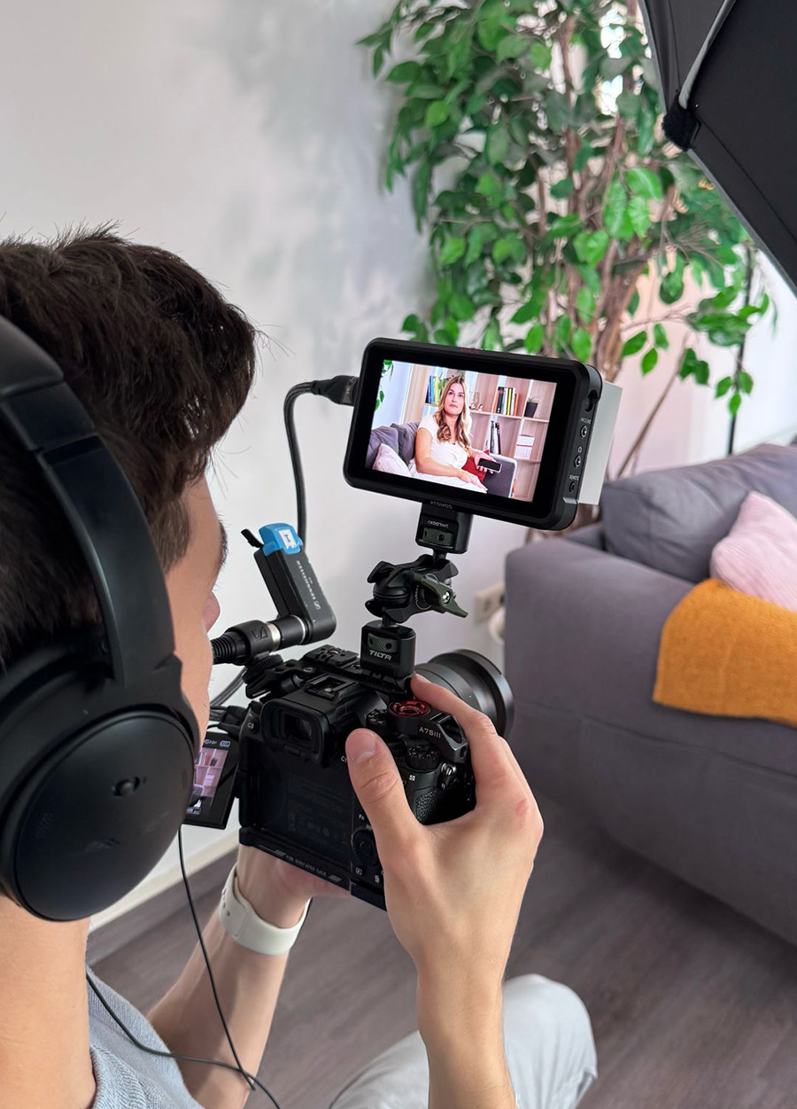 Moderatorin auf einem Sofa mit Kamera auf sie gerichtet