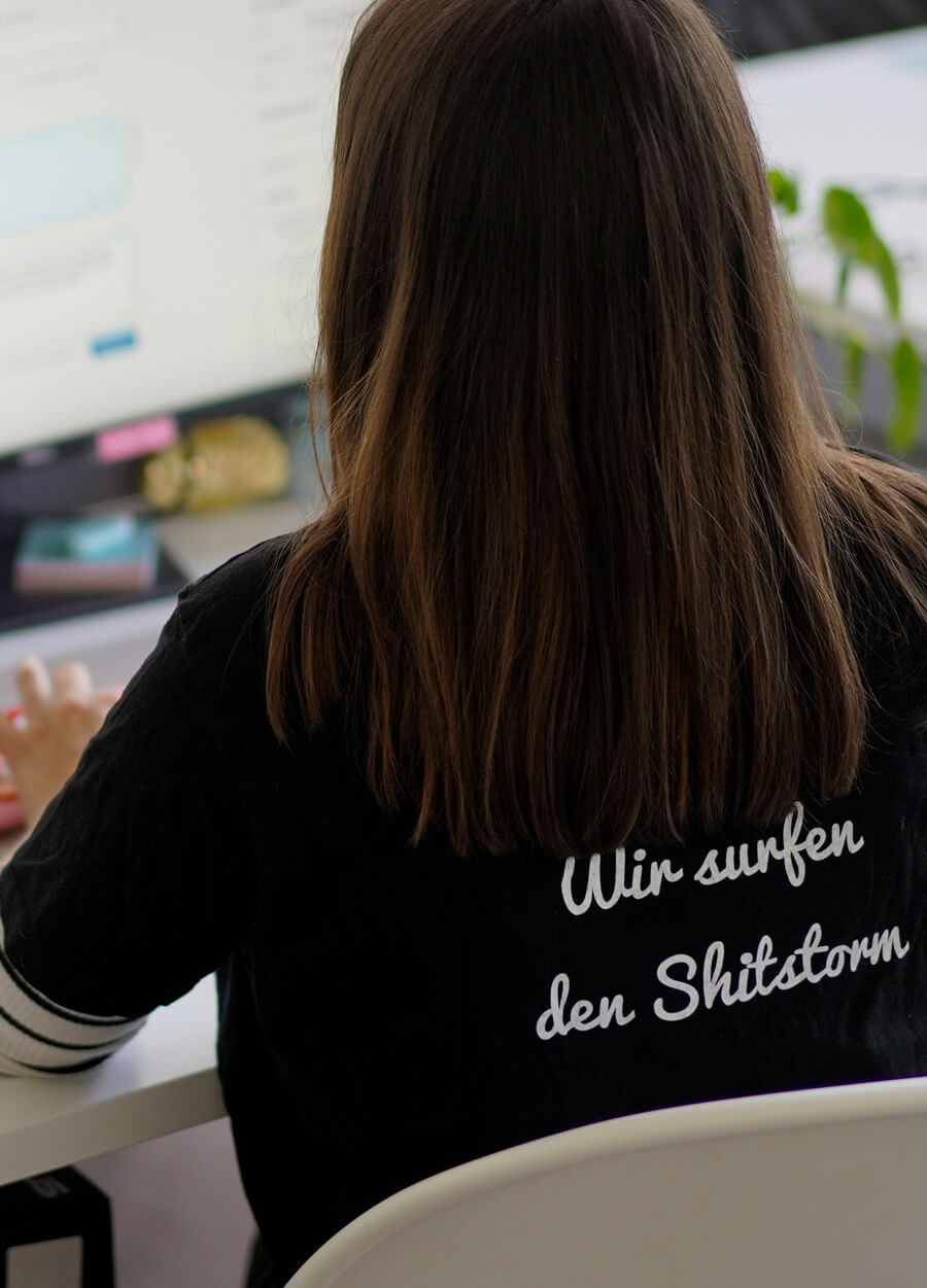 Frau mit Tshirt Aufschrift Wir surfen den Shitstorm